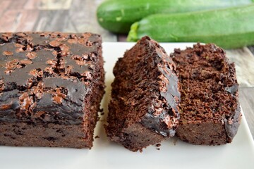 Zucchini chocolate cake. Moist double chocolate cake with grated zucchini, cocoa powder, chocolate and chocolate chips. Shot on wooden background