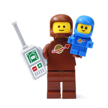 Lego minifigure of astronaut with baby in space suit. Editorial illustrative image of popular plastic toys brand. Serie 24.