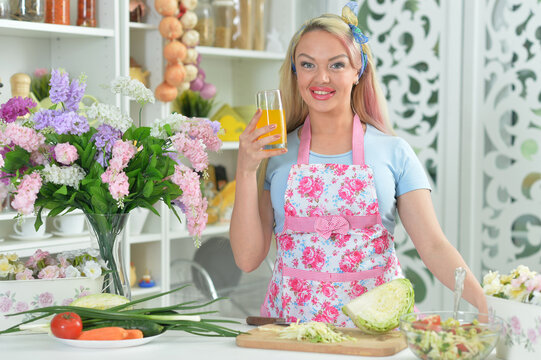 cute young woman cooking salad in kitchen