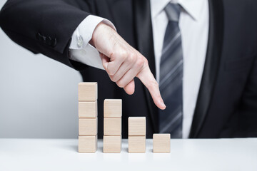 Wooden cubes, business loss decline concept, pointing down