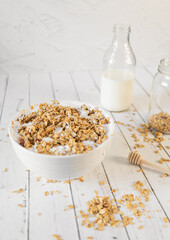 Granola and milk with glass and honey spoon