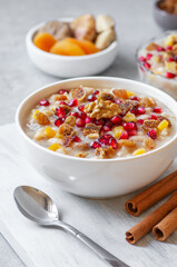 Traditional Turkish delicious mixed dessert, ashura (asure) with pomegranate seeds, walnut,...