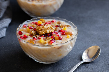 Traditional Turkish delicious mixed dessert, ashura (asure) with pomegranate seeds, walnut, apricot, Noah’s pudding