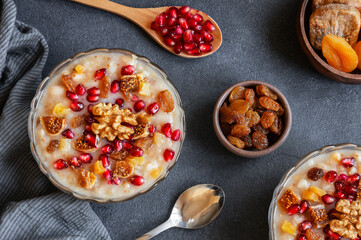 Traditional Turkish delicious mixed dessert, ashura (asure) with pomegranate seeds, walnut,...