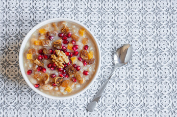 Traditional Turkish delicious mixed dessert, ashura (asure) with pomegranate seeds, walnut, apricot, Noah’s pudding