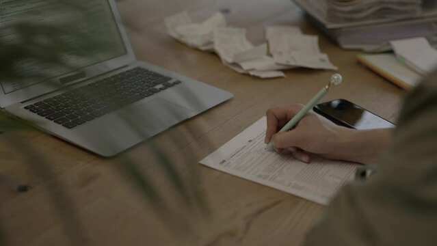 Female fills up the tax form at the table