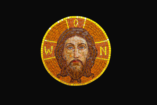 Ancient mosaic of Jesus Christ against black background.