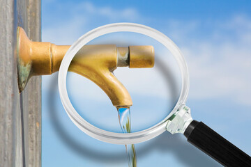 Control of purity and quality of drinking water - concept with a water brass faucet seen through a...
