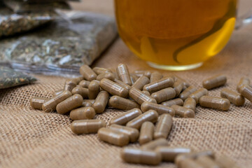 Herbal capsules with homeopathic products, natural herbal tea in sachets and bags on burlap...