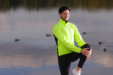Fototapeta premium Man Stretching Legs During Running Exercises Outdoor