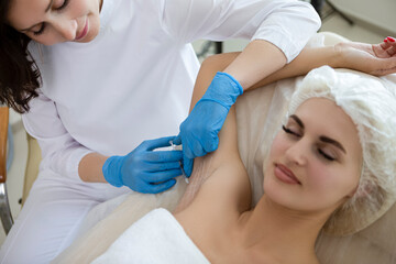 Beauty Injections and Cosmetology Concepts. Winsome Young Caucasian Woman While Getting Armpits Injection Therapy Process in Beauty Cosmetology Salon.