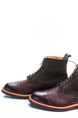 Footwear Ideas. Closeup of Premium Dark Brown Grain Brogue Derby Boots Made of Calf Leather with Rubber Sole Placed in Line Together Over White Background.