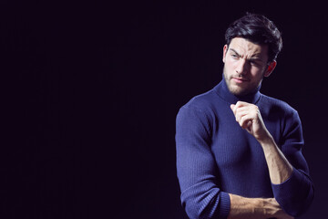 One Calm Caucasian Handsome Brunet Man Posing in Blue Turtle Neck Sweater With Folded Hands Against Grey Background as Successful Young Man.
