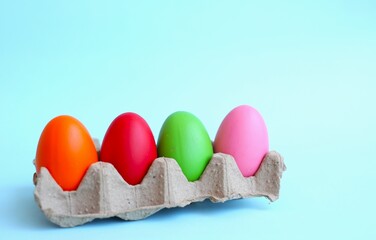 multi-colored Easter eggs, hand-painted by children, lie on a blue background, top and side view