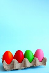 multi-colored Easter eggs, hand-painted by children, lie on a blue background, top and side view