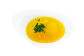 Golden broth with herbs in a white bowl. Traditional appetizing dish. Close-up. Isolated on white...