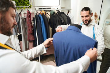 Two tailors involved in custom-making client suit
