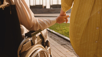 Man with reduced mobility holding wife's hand, support in relationship, love
