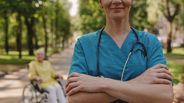 Happy female doctor crossing arms on chest, care for people with disability, traumatology
