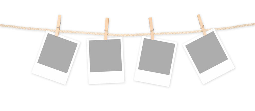 Four blank polaroid frames and clothespins attached to a rope isolated on white background. Clipping Path Included.