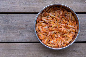The top view prawns is a seafood. Bring it to boil until cooked to make an orange color look appetizing. In silver tray That was placed on brown wooden block. Copy space