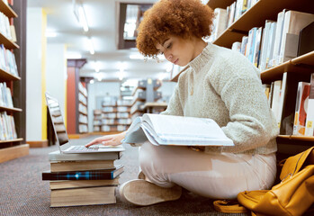 College learning, library and book reading with laptop of a black woman student on the ground....