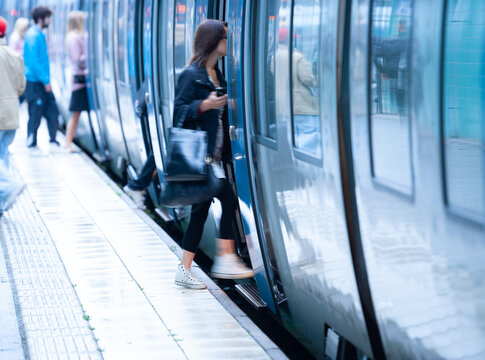 Anonymous motion blurred woman entering commuter train