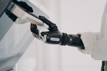 Moves and touches of robotic cyber hand. Disabled person going to cook in oven.
