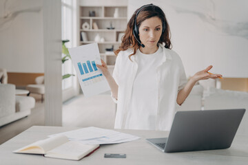 Tough woman has internet session on laptop. Girl demonstrates charts and works on startup project.