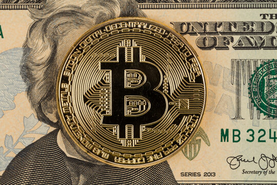 Golden bitcoin coin on dollar