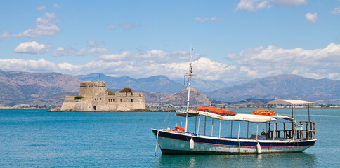 Barca per visite turistiche in rada nel porto di Nafplio con dietro il Bourtzi Castle. Peloponneso, Grecia