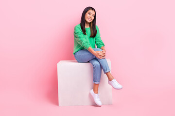 Full length portrait of cheerful satisfied person sitting podium have good mood isolated on pink color background