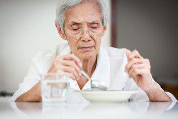 Sick asian senior woman suffering from anorexia,bored with meal,eating less food or discomfort in...