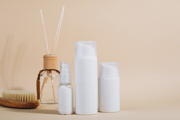 Three bottles with gel, champoo and cream with a brush and a hair comb on a white table in a bathroom