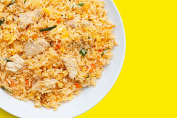 Fried rice in white plate on yellow background. Top view