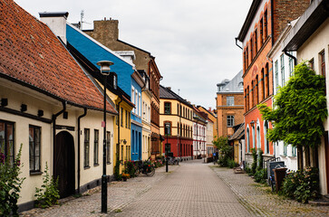 Fototapeta na wymiar Historical alley with typical Swedish houses in Malmo Gamla Stan, Malmö old town. Swedish cobbled alleyway with bicycles shows the Nordic architecture