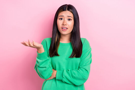 Photo of shocked confused lady wear green sweatshirt can not understand you isolated pink color background