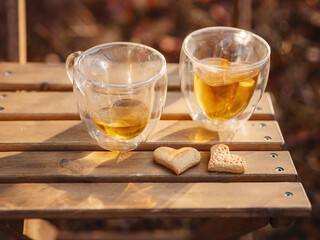Drinking tea with cookies on wooden table. Cozy autumn mood scene in autumn park - 565288402