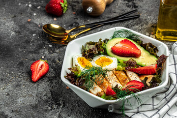 Keto breakfast two eggs, avocado, strawberry, grilled chicken fillet, nuts and fresh salad, Ketogenic diet. Plate with keto diet food. Healthy food concept, top view