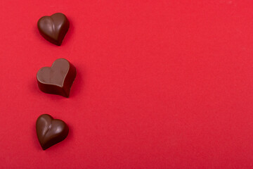 Valentine's day background. Heart-shaped chocolates on red felt