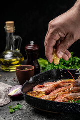 Grilled tiger shrimps with spice, lemon and garlic in a frying pan on a dark background. Prawns fried, Seafood appetizer, Culinary, cooking concept, top view