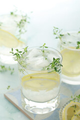 Glasses with lemon and thyme refreshing drink