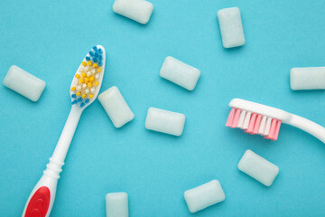 Toothbrush and chewing gums on a pastel blue background. Minimal concept
