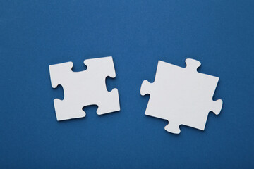 Obraz premium Two blank white puzzle pieces on blue background