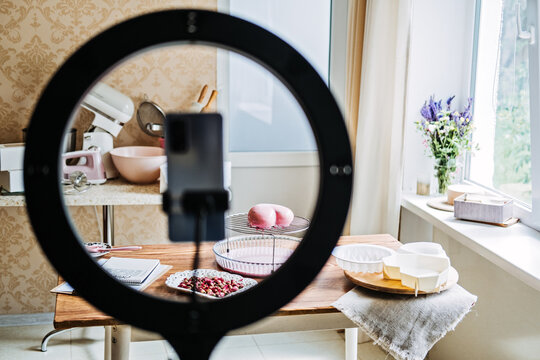 Online classes and workshops on cake decorating and baking. Female Confectioner baker make custom pink heart shape cake in kitchen Bakery.