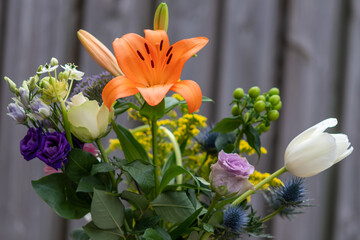 Bouquet flowers with a purple rose, an orange lilly and a white tullip