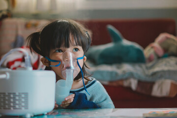Girl using Oxygen breathing machine at home smile and surprice. Breathing device for asthma and...