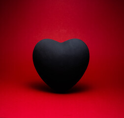 black heart on red background with shadow