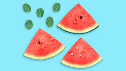 Red watermelon and green mint leaves on a blue background.
