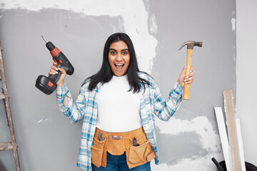 A young woman looks excited to start DIY holding hammer and screwdriver